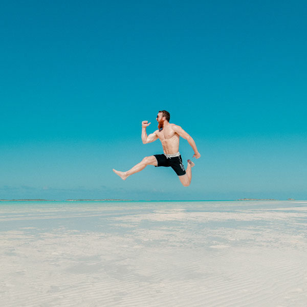 happy-man-jumping-with-water-in-background happy-man-jumping-with-water-in-background